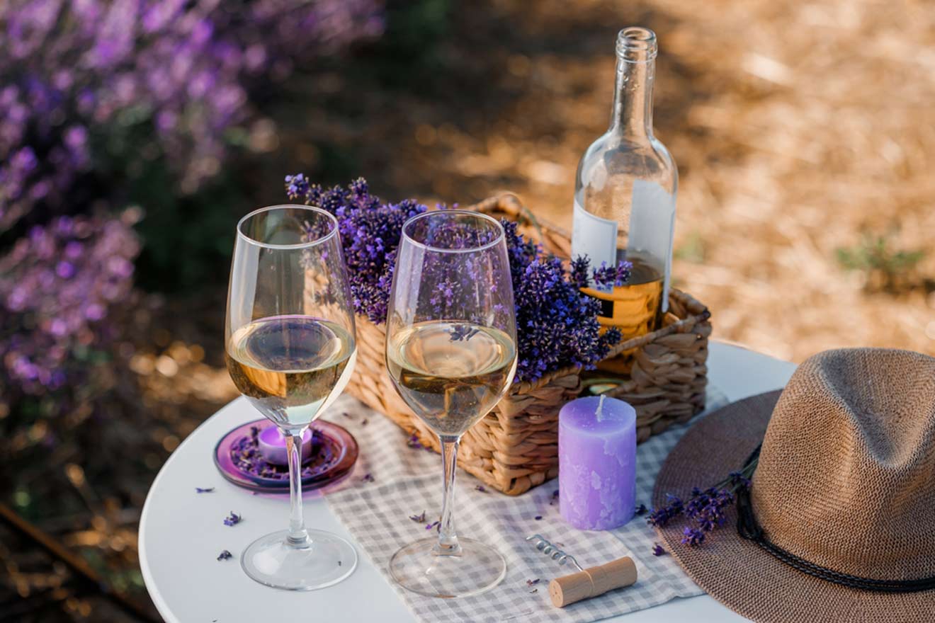 two glasses of wine and a hat on a table