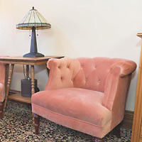 Two pink chairs in a room.