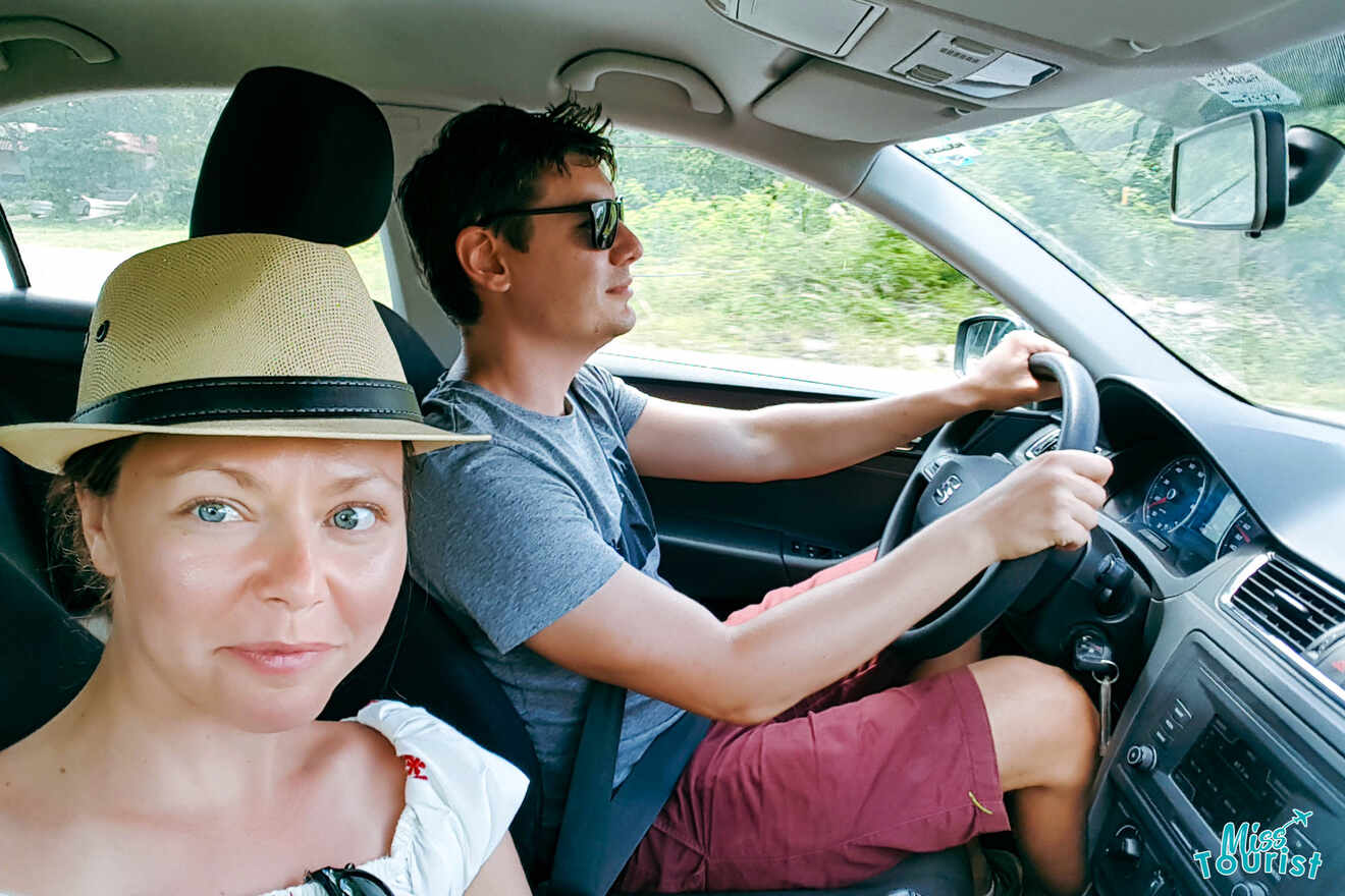 A man and woman sitting in the driver's seat of a car.