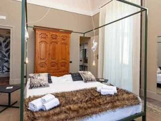 A bedroom with a four poster bed and a fur rug.