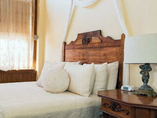 A bed in a room with a bedside table and lamps.
