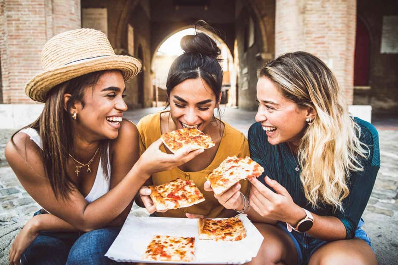 girls eating pizza on the street