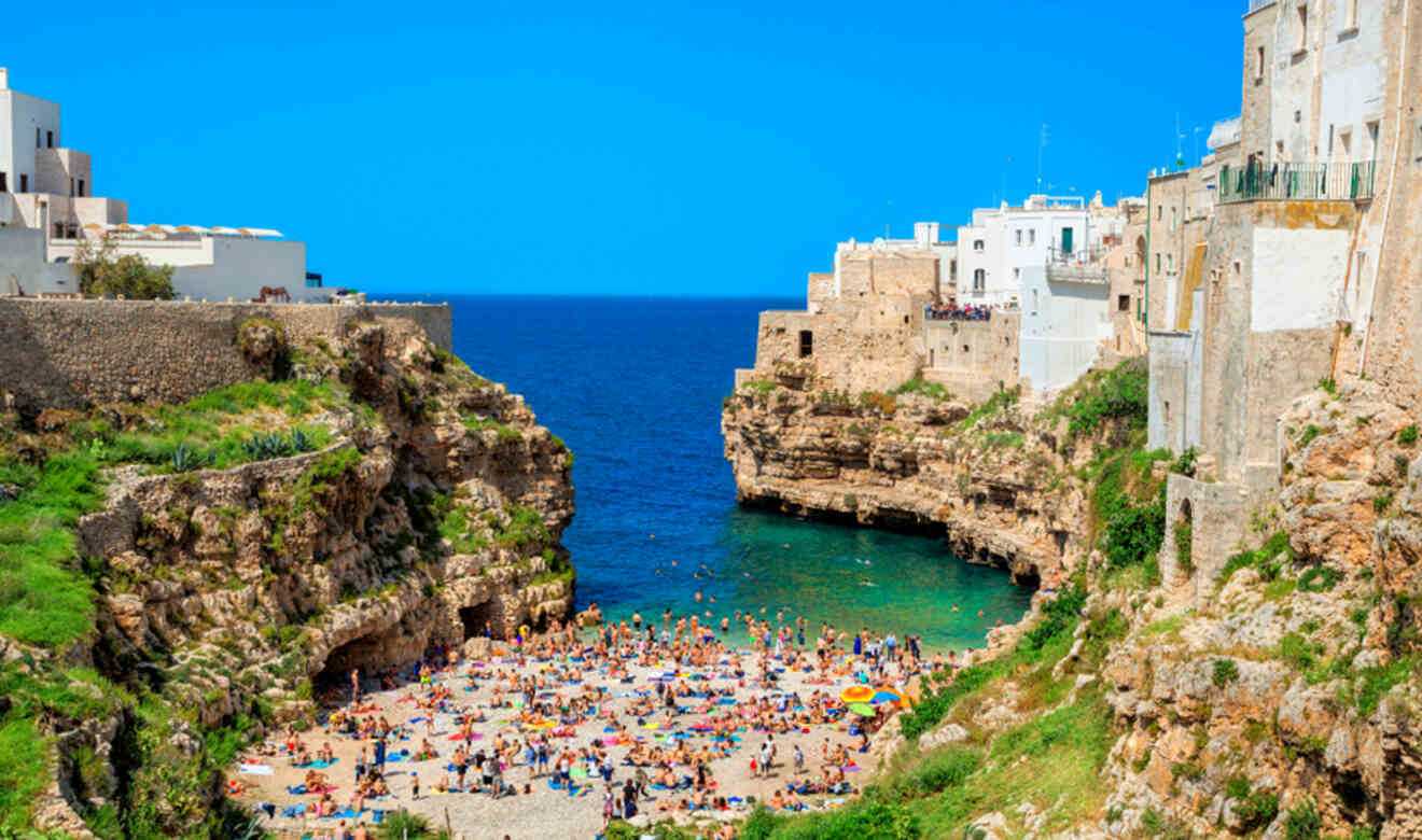 people on a crowded beach between cliffs