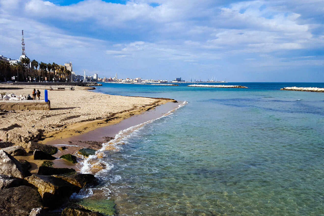 A beach with rocks and water in the background.