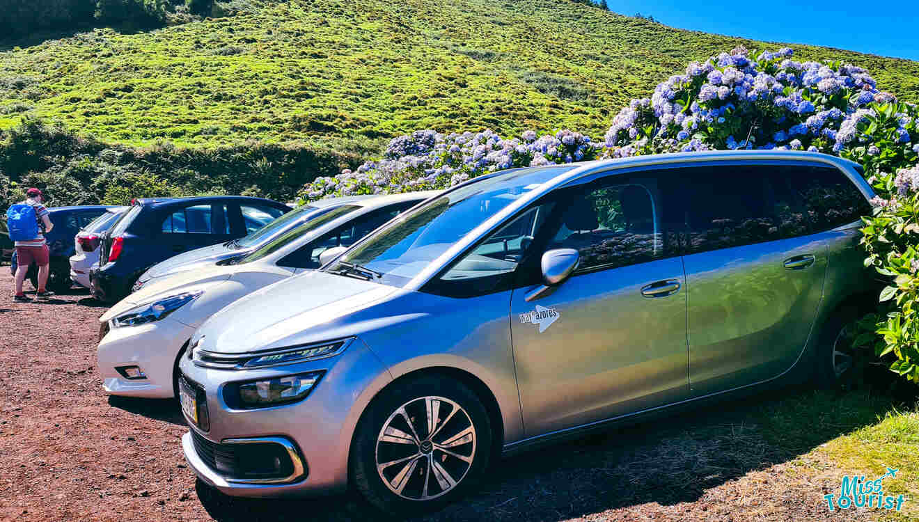 A group of cars parked on the side of a hill.