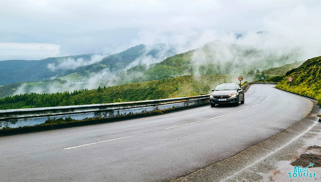 A car driving down a winding road in the mountains.