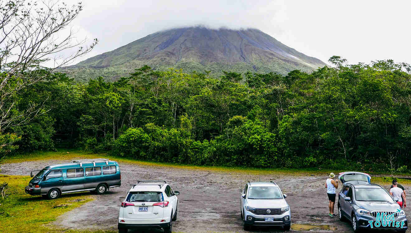 A group of cars parked in front of a volcano.