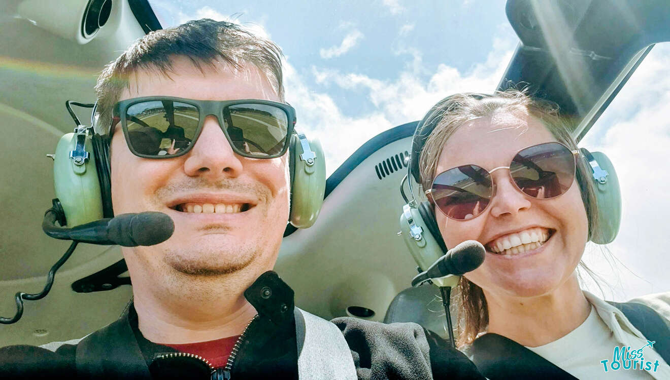 a man and woman wearing sunglasses and headphones in a cockpit helicopter