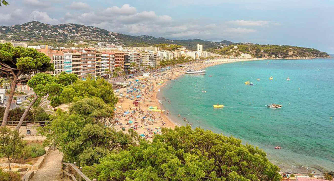 aerial view of people on a beach and buildings in the background