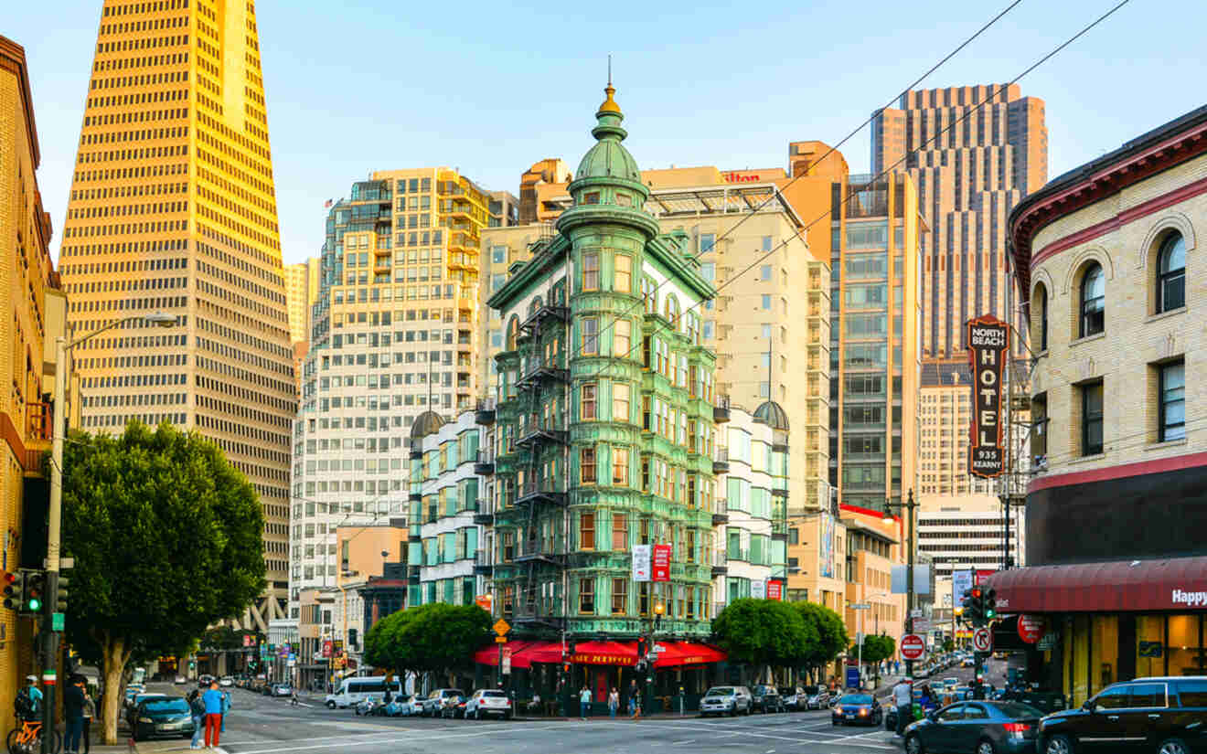 view of an old green building on a corner of a street in a city