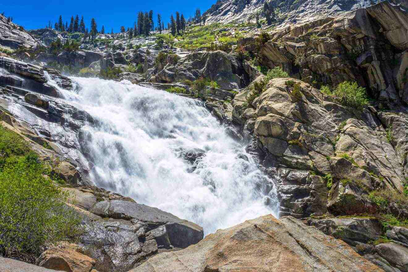 A waterfall surrounded by rocks and trees.