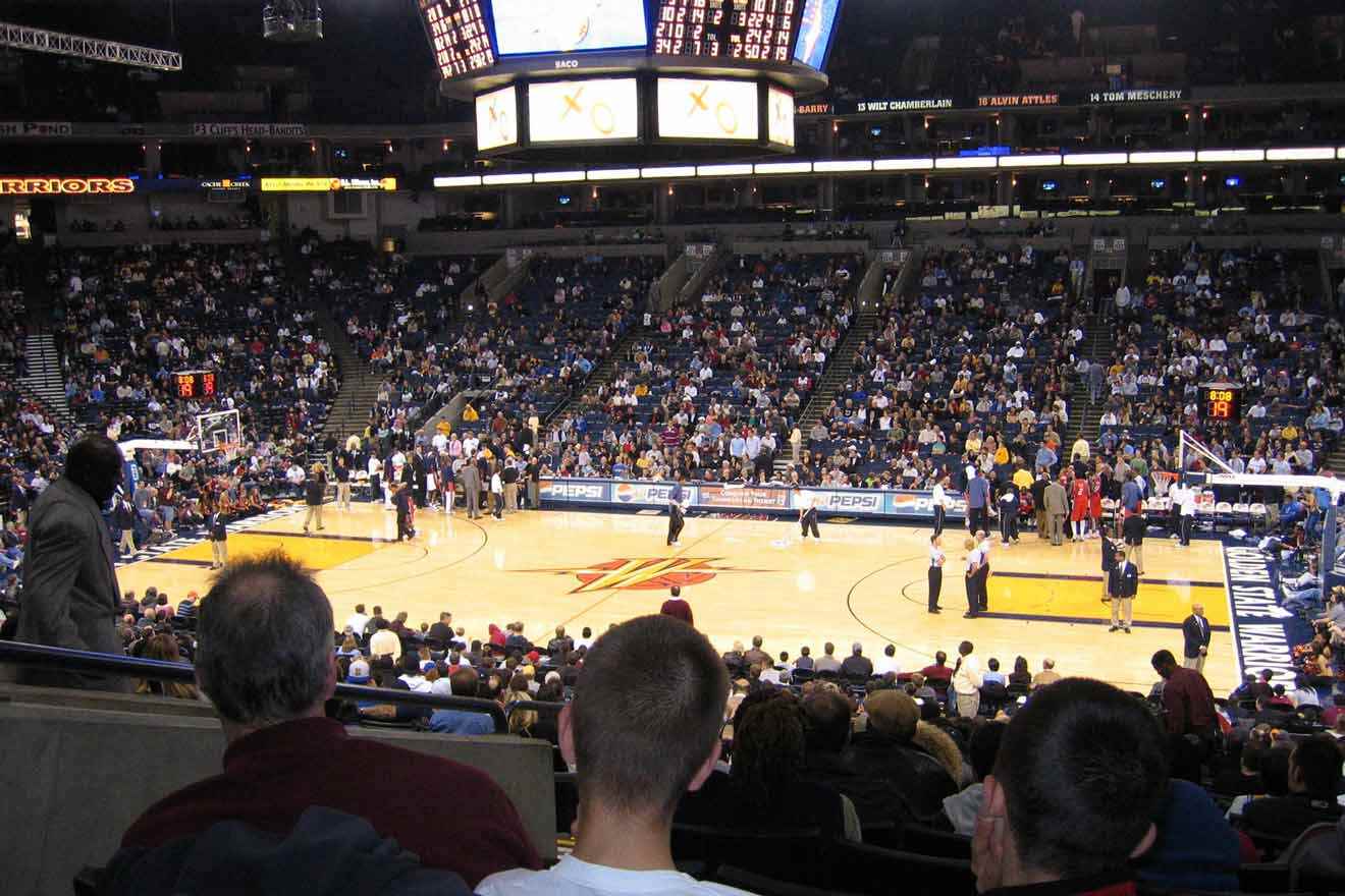 A crowd of people watching a basketball game in a stadium.