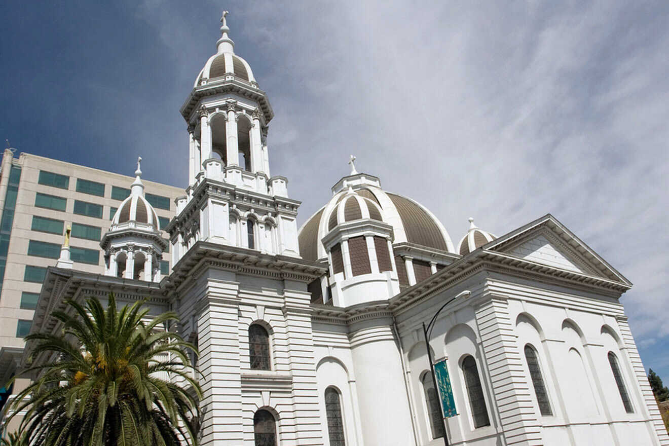 white building housing a church with various towers and palm trees