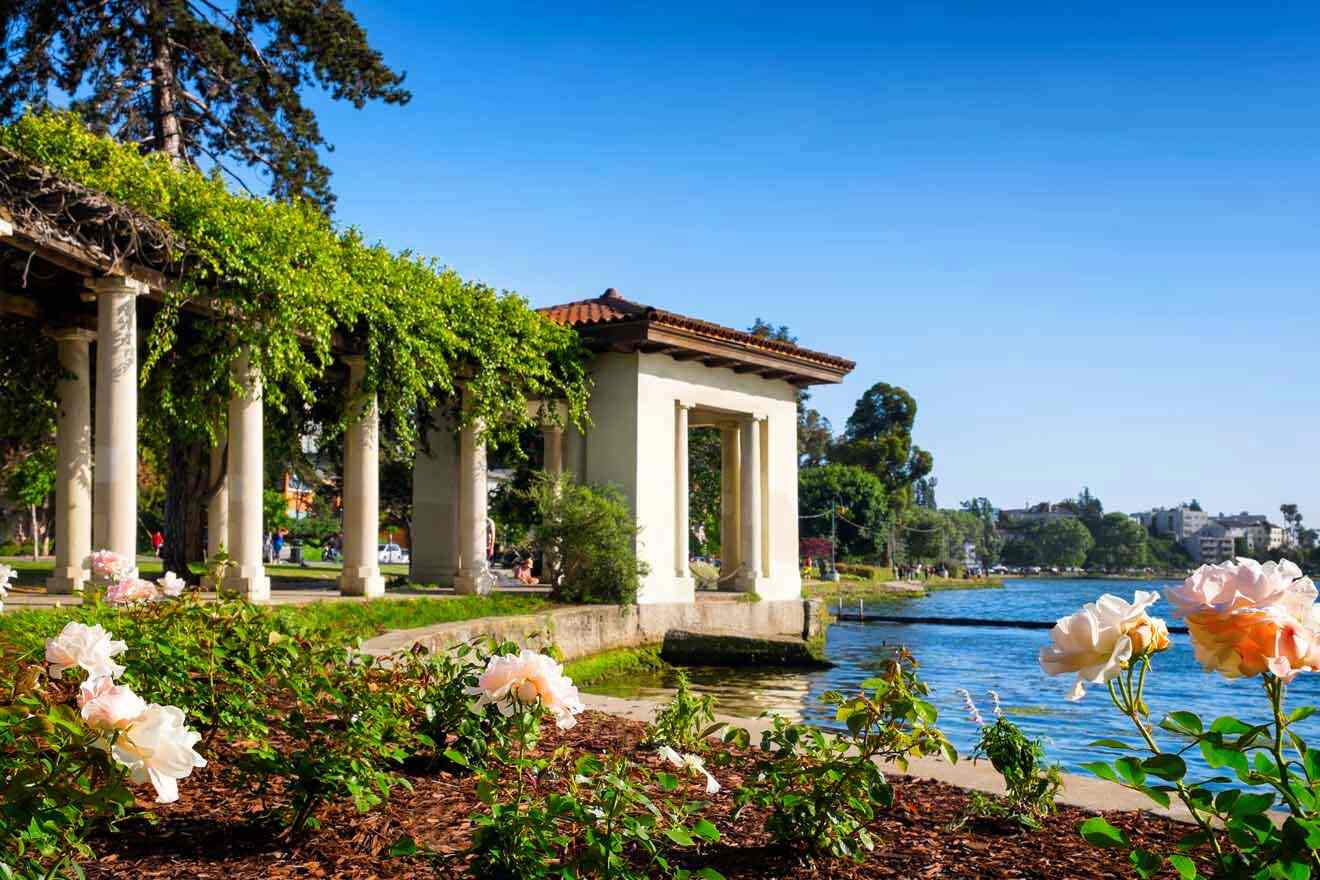 A gazebo with roses in front of a lake.