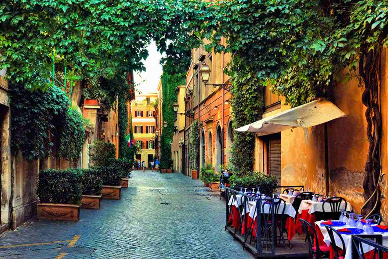 A cobblestone street lined with tables and chairs.