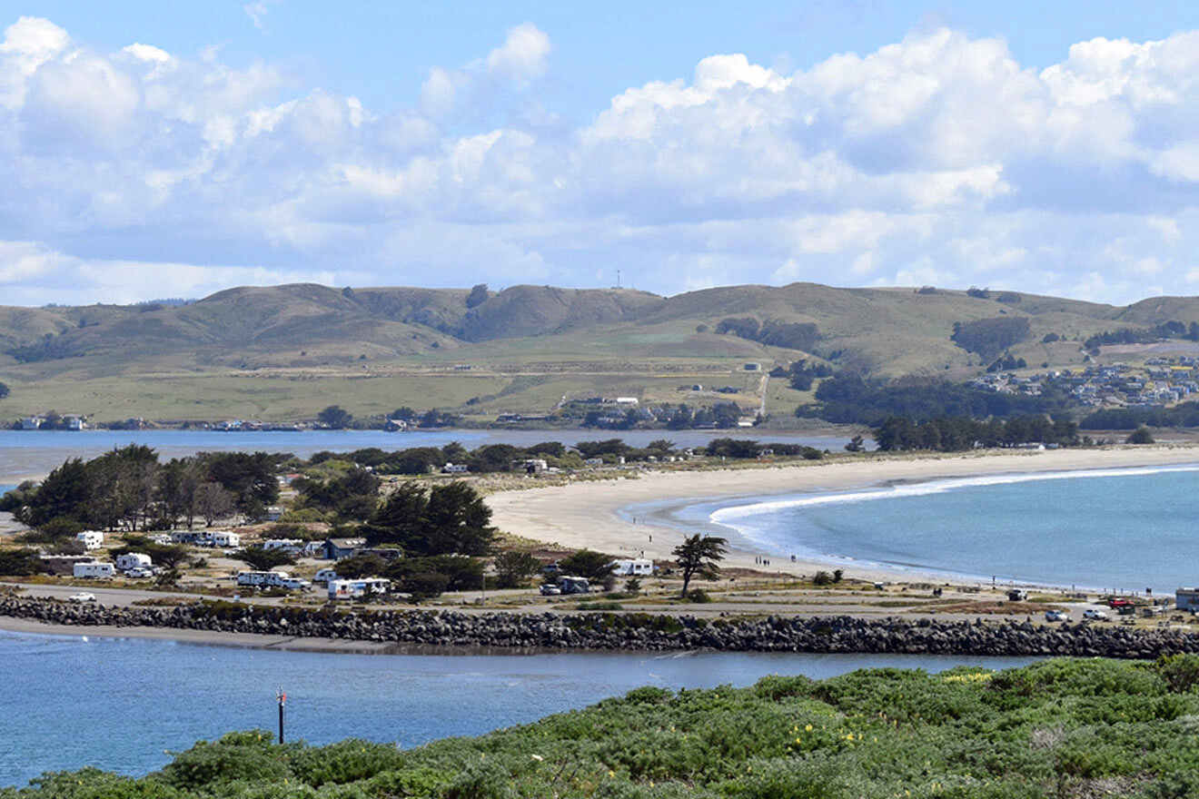 A view of a beach with a hill in the background.