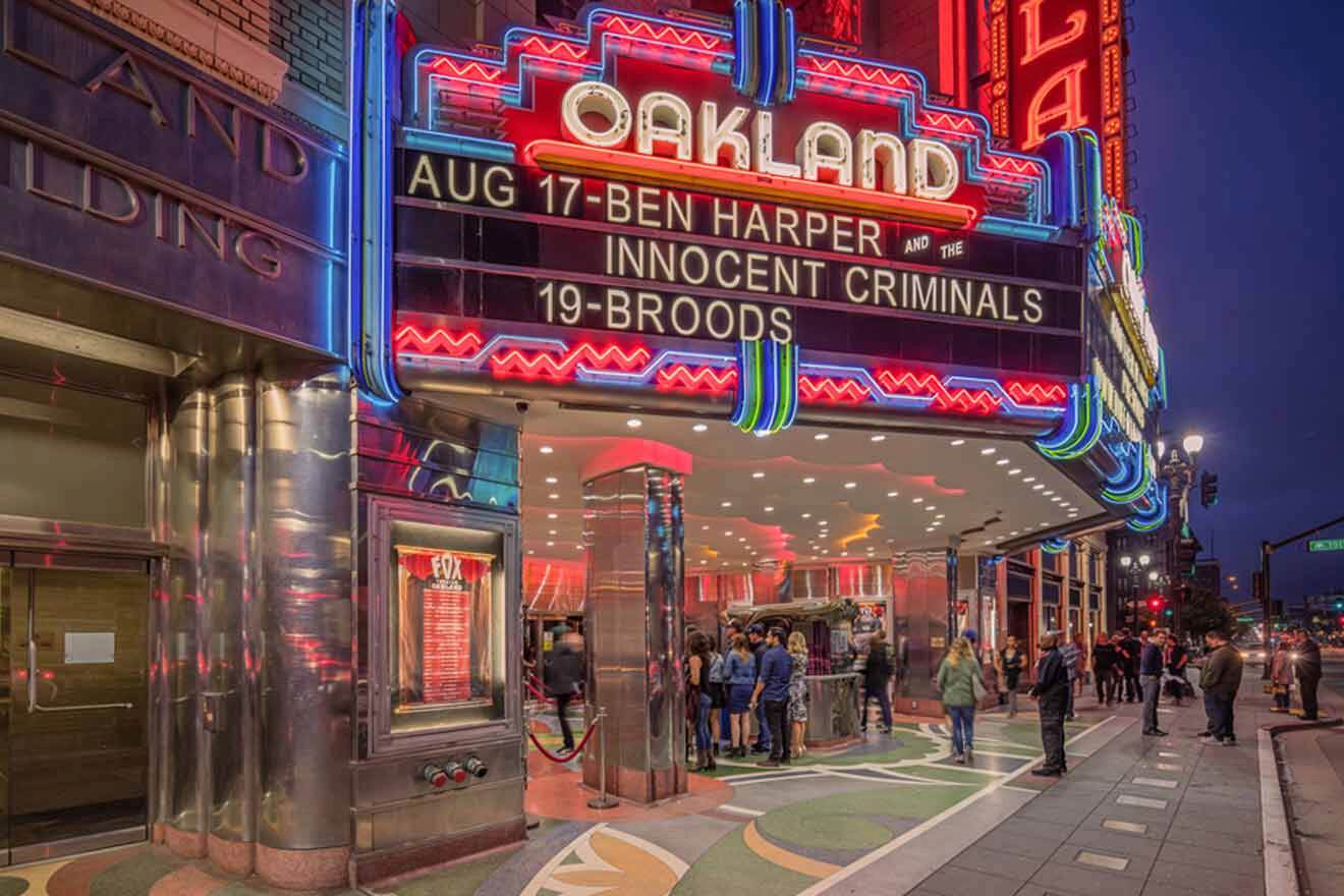 A group of people standing in front of an oakland theater.