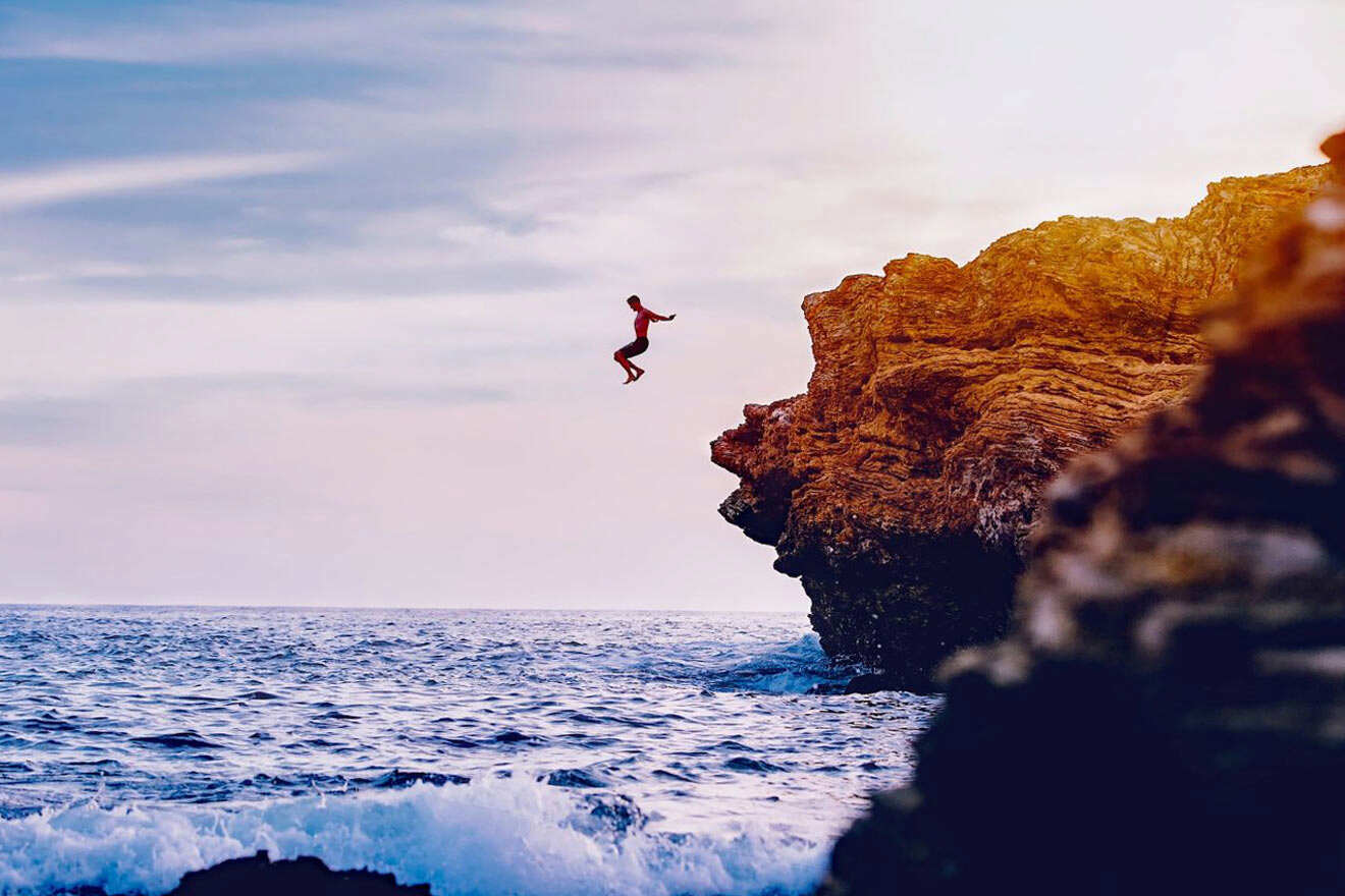 man jumping off a cliff