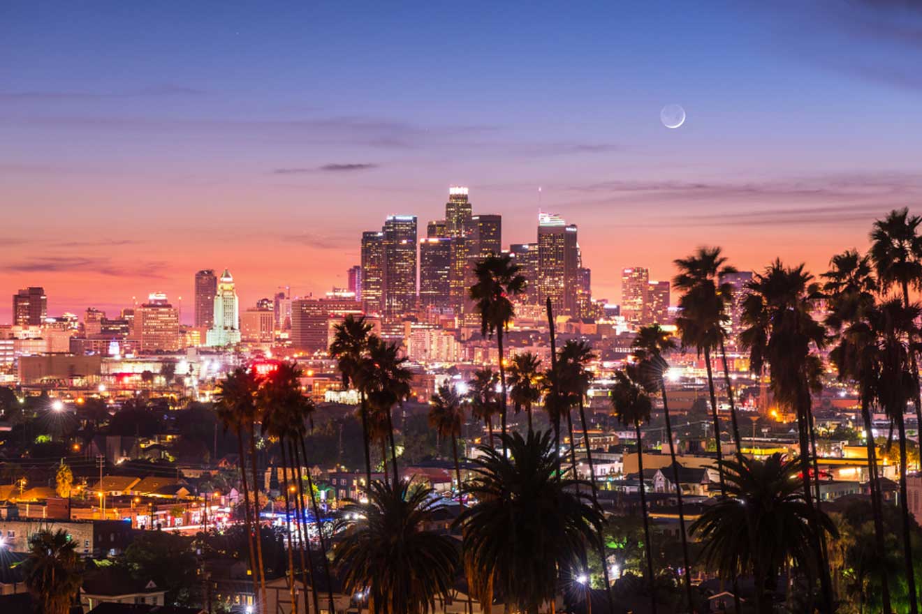 The Los Angeles skyline at dusk with palm trees