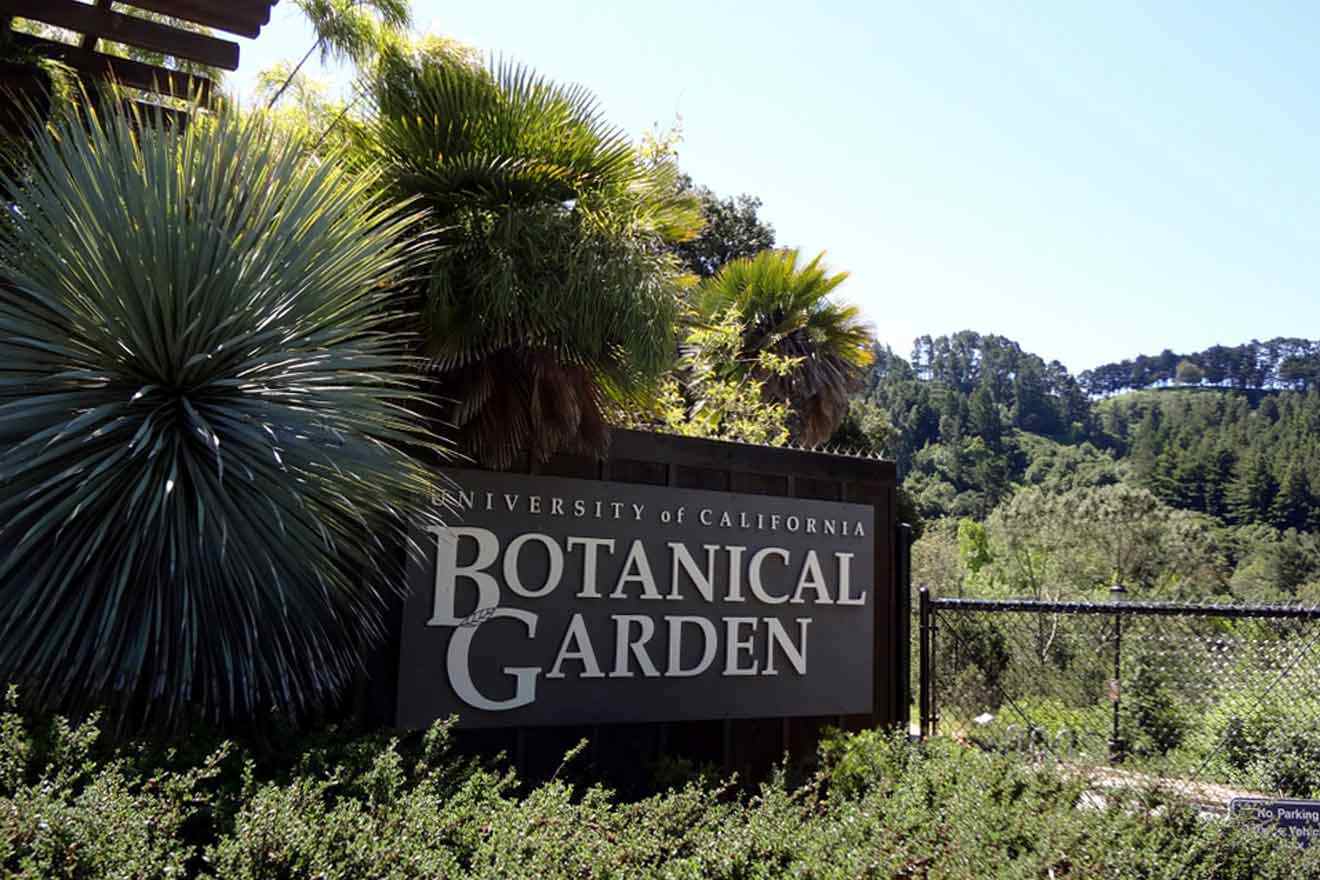 A sign for botanical garden in front of bushes and trees.