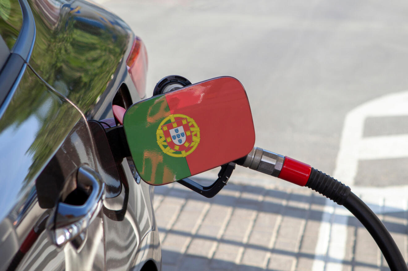 A car with a portuguese flag on the gas pump.