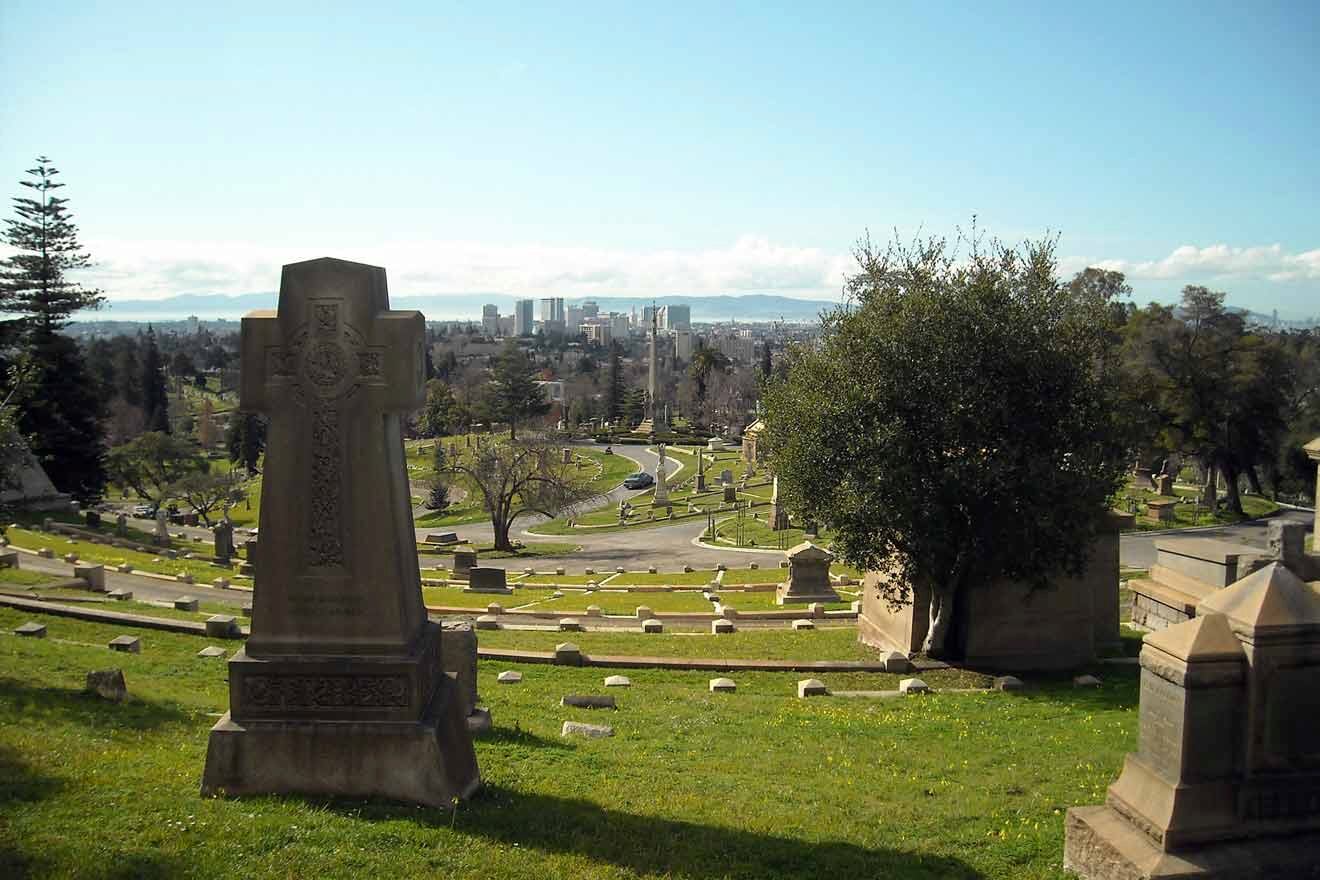 A view of a cemetery with a city in the background.