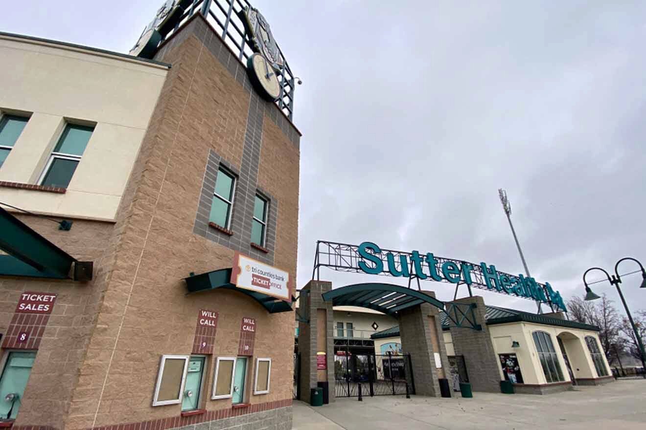 The entrance to a stadium with a clock on it