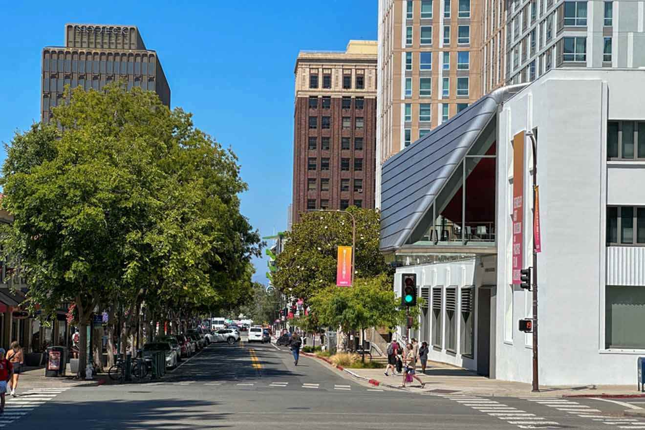 A city street with tall buildings and people walking down the street.