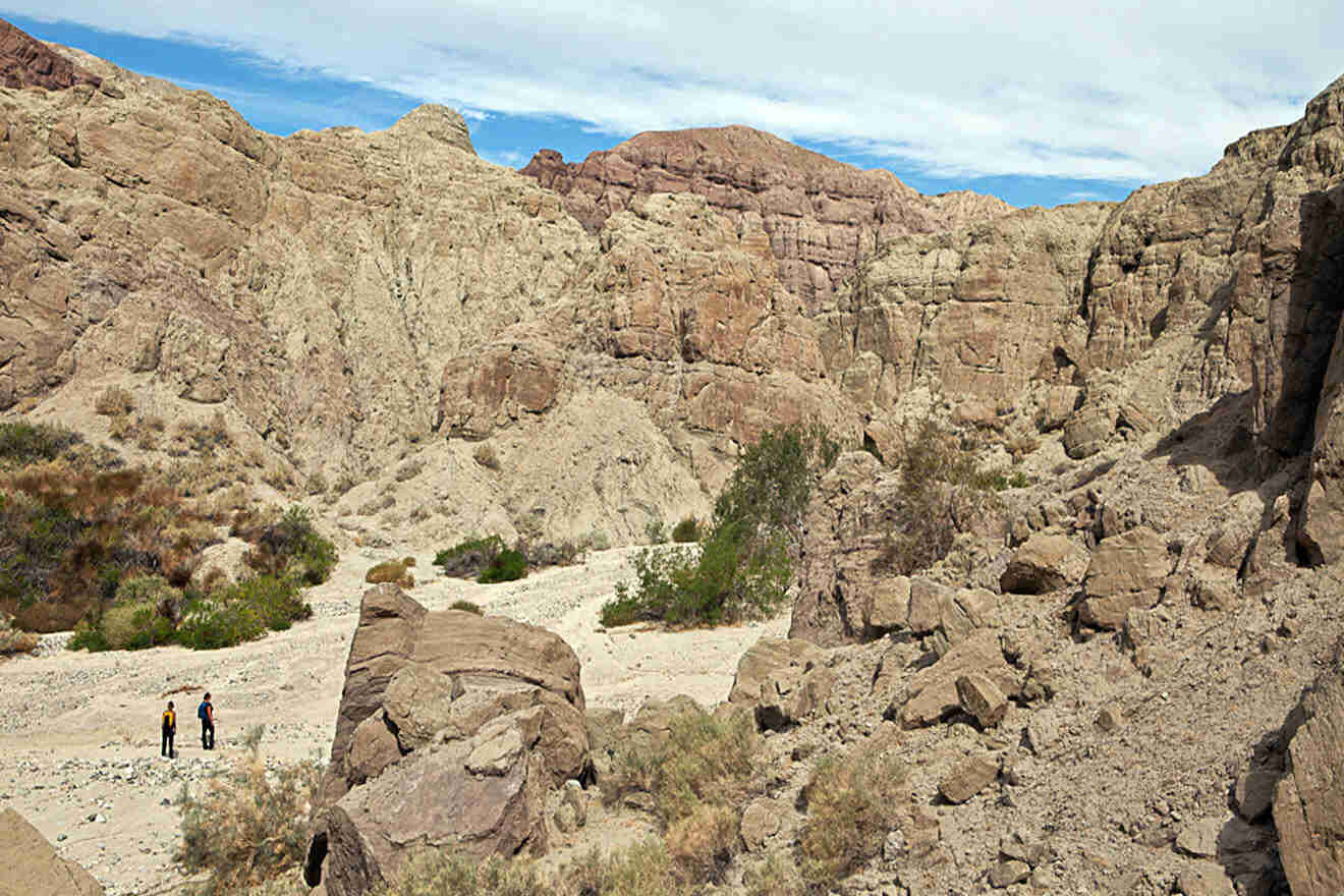 A group of people are walking through a rocky area.