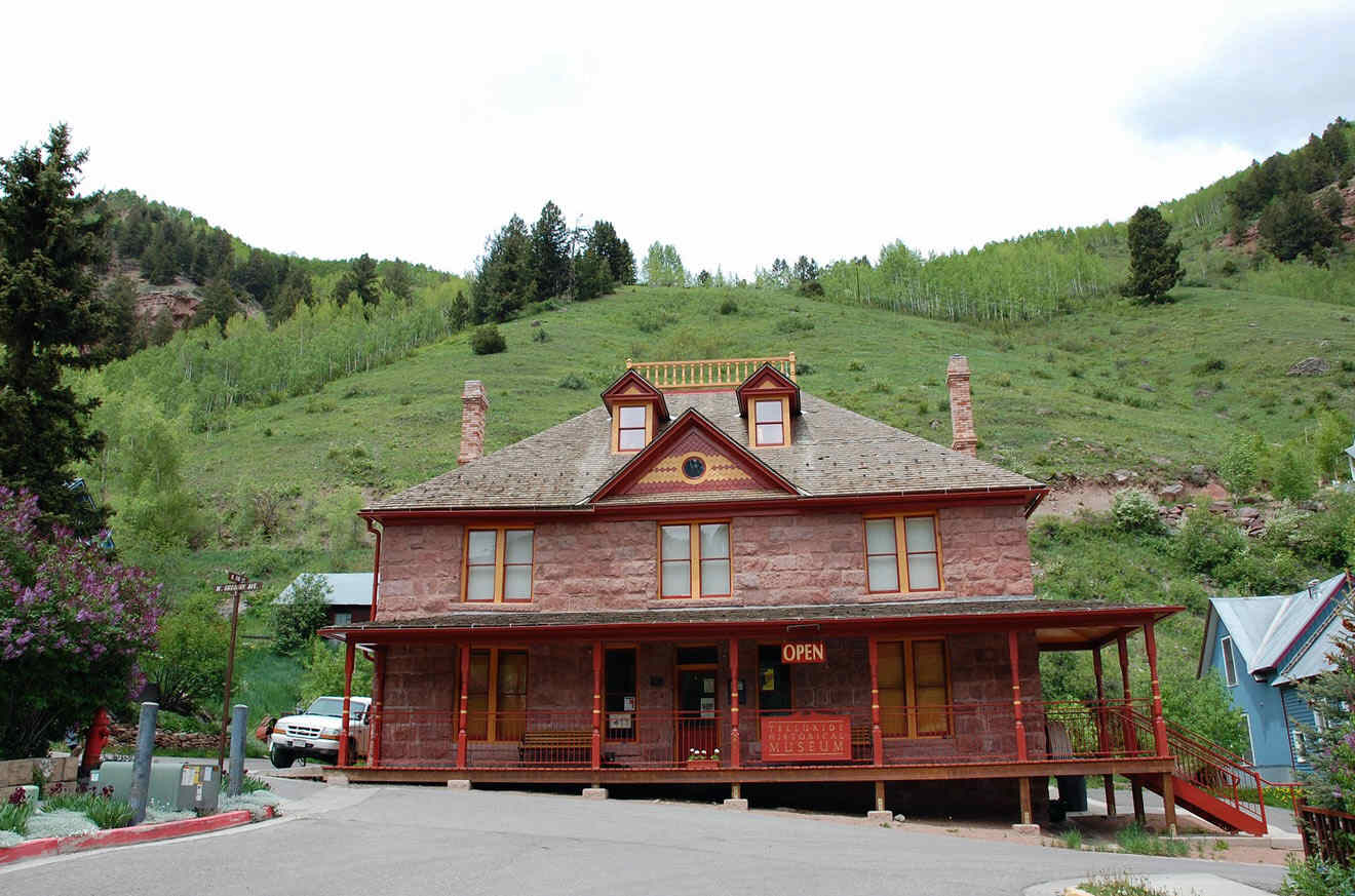 A red brick house on the side of a hill.