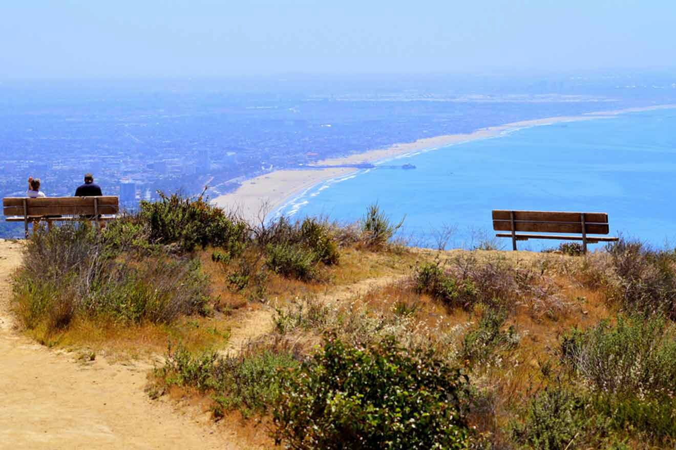 tourists on top of a mountain overlooking the city and ocean