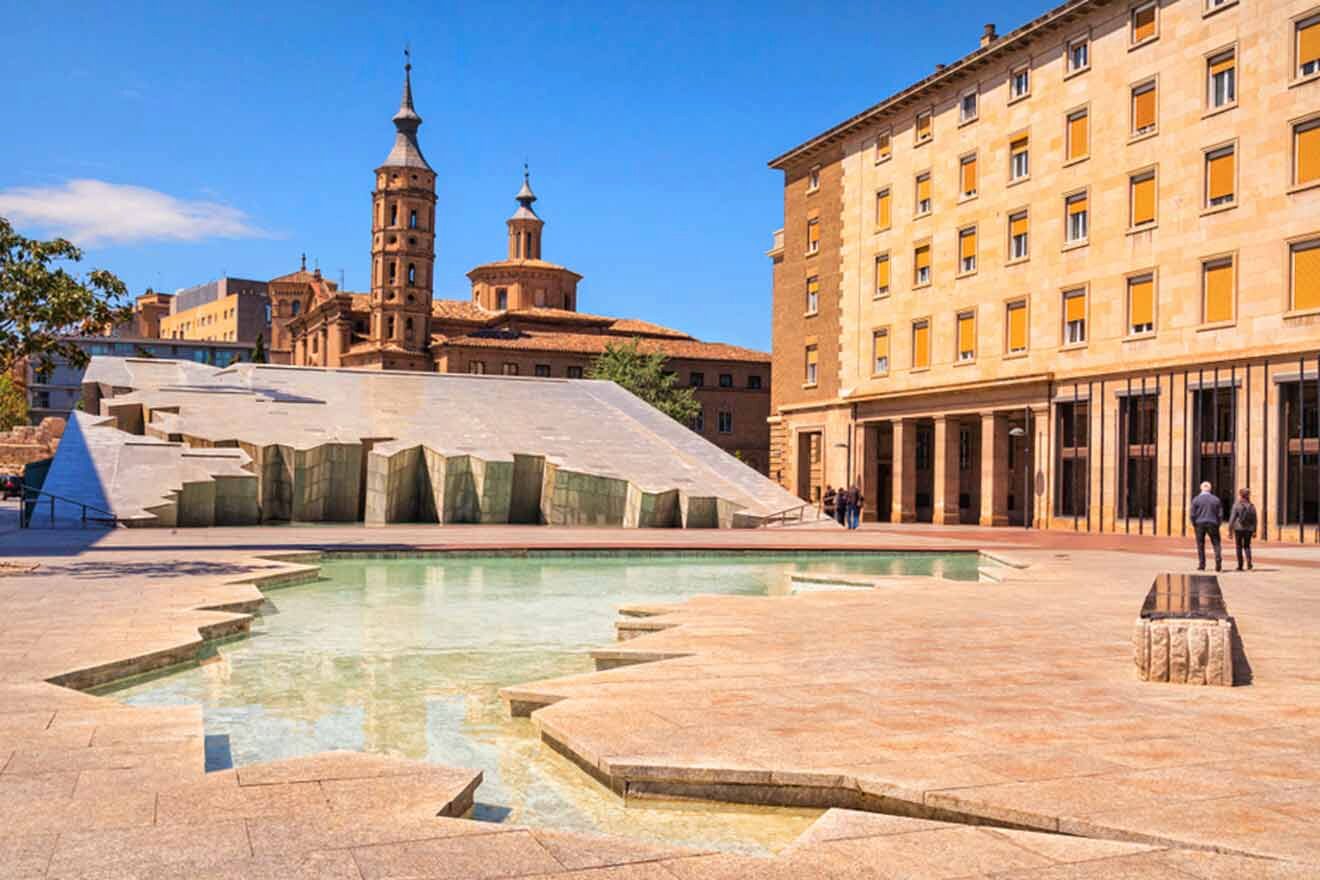 a fountain in the middle of a courtyard with a building in the background