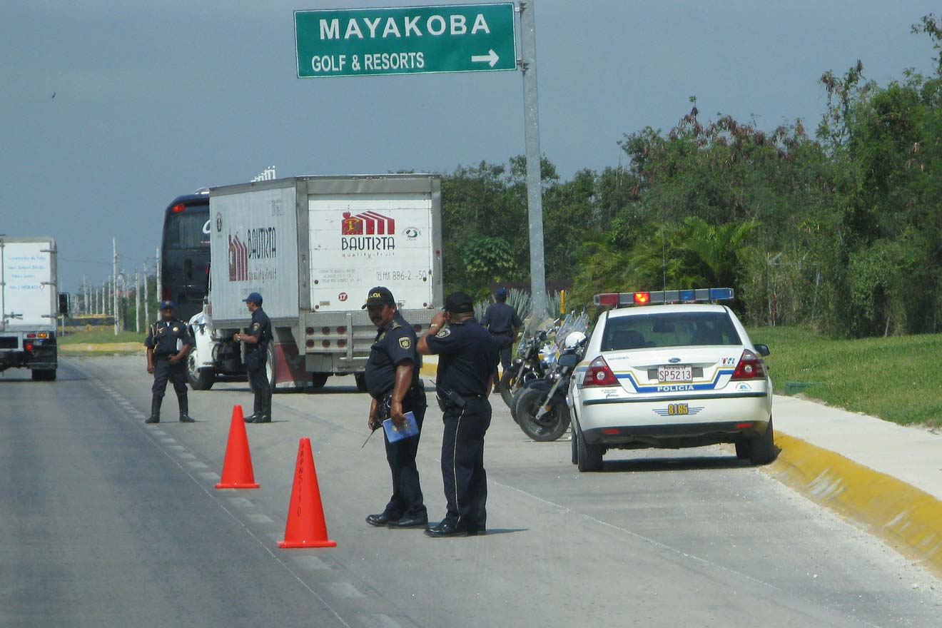 Two police officers standing on the side of the road.