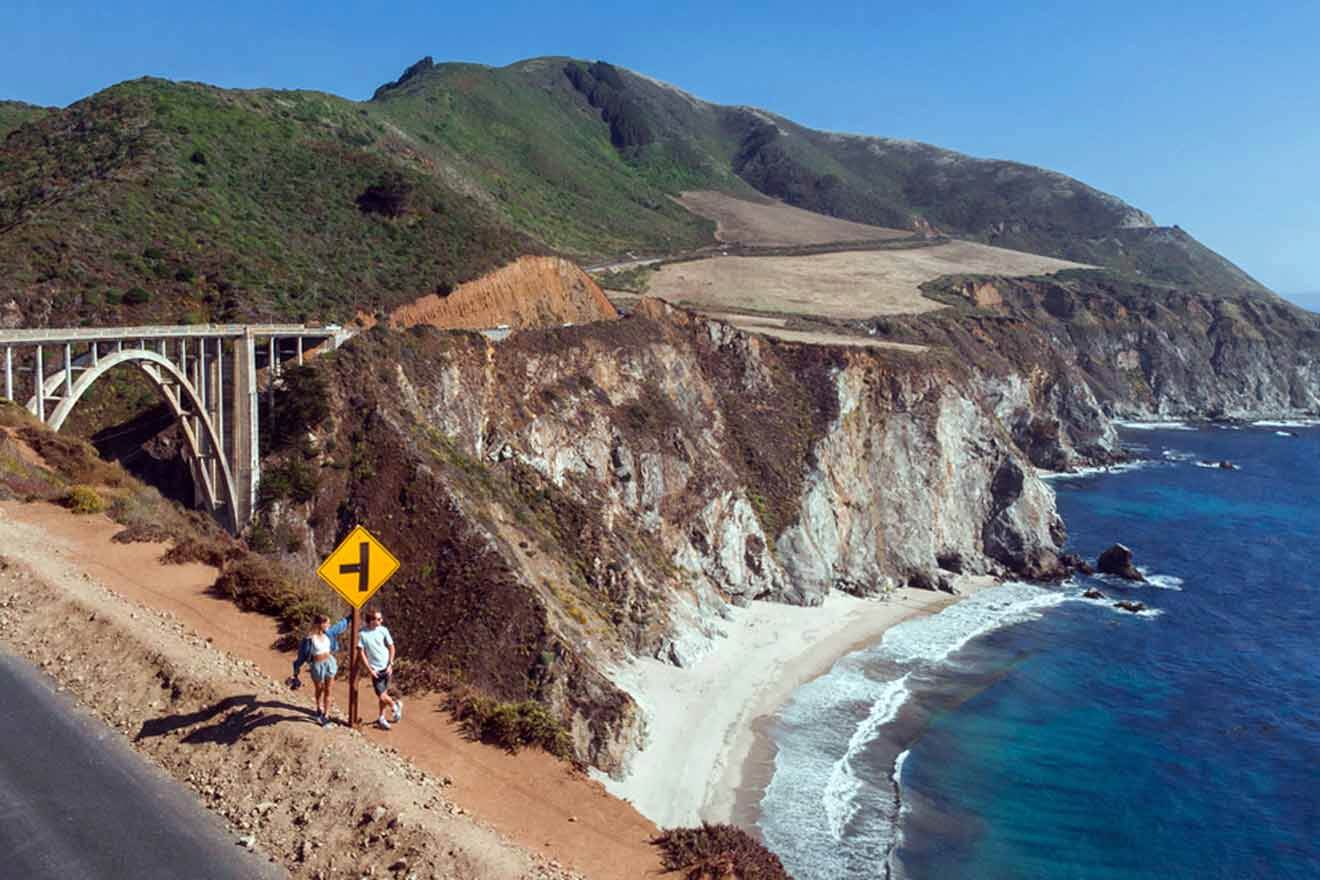 couple taking a picture near a bridge by the ocean