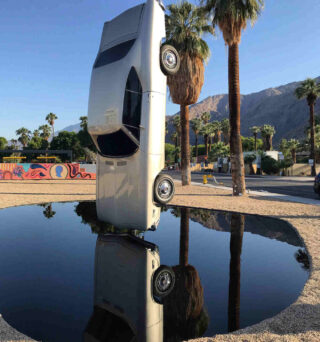 A car is upside down in a puddle near palm springs.