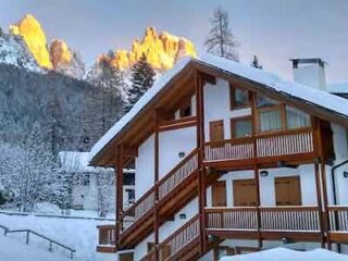 A house in the snow with mountains in the background.