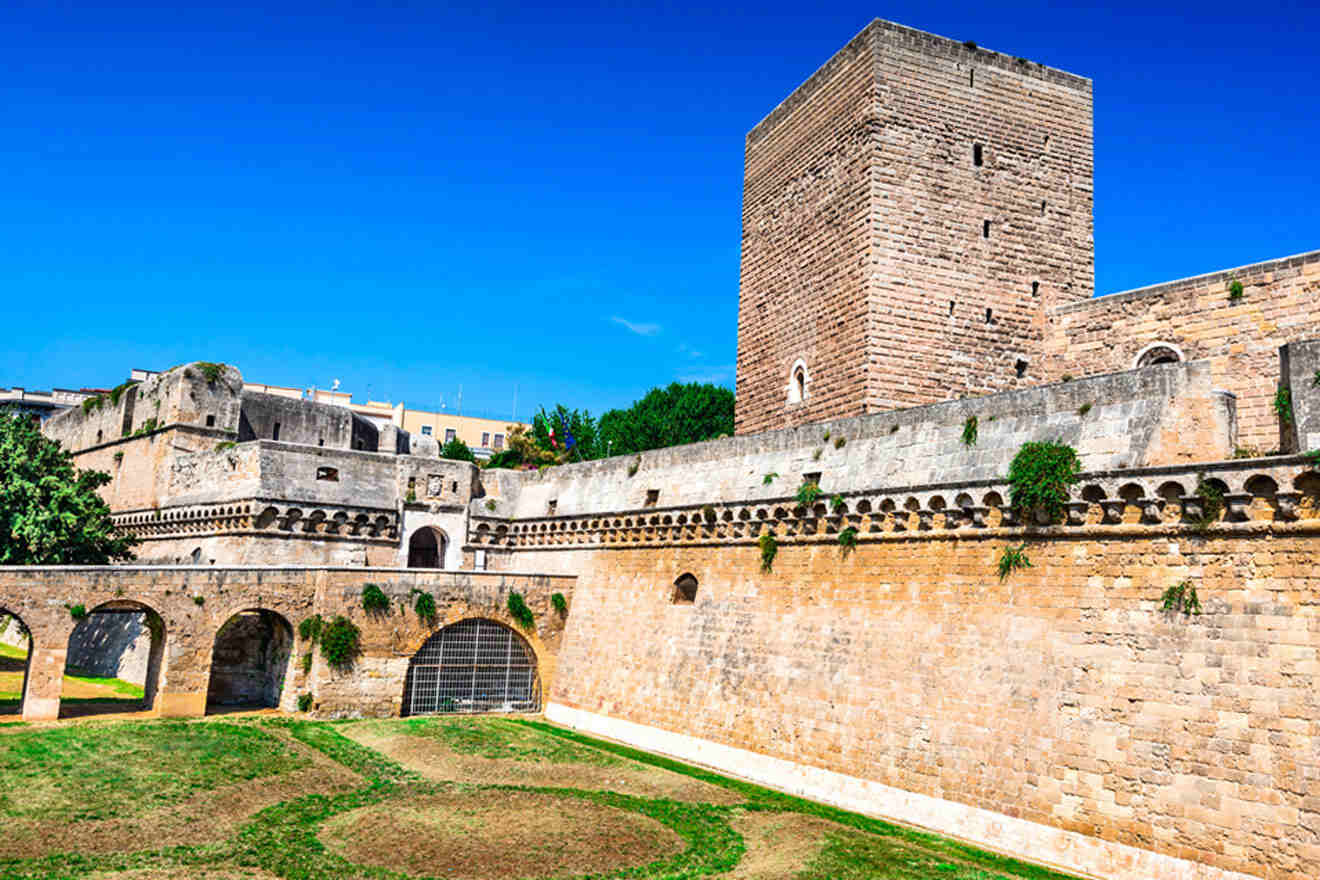 A castle with a green lawn and a stone wall.