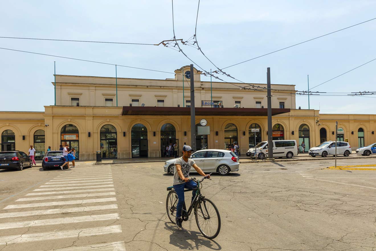 A man riding a bicycle in front of a train station
