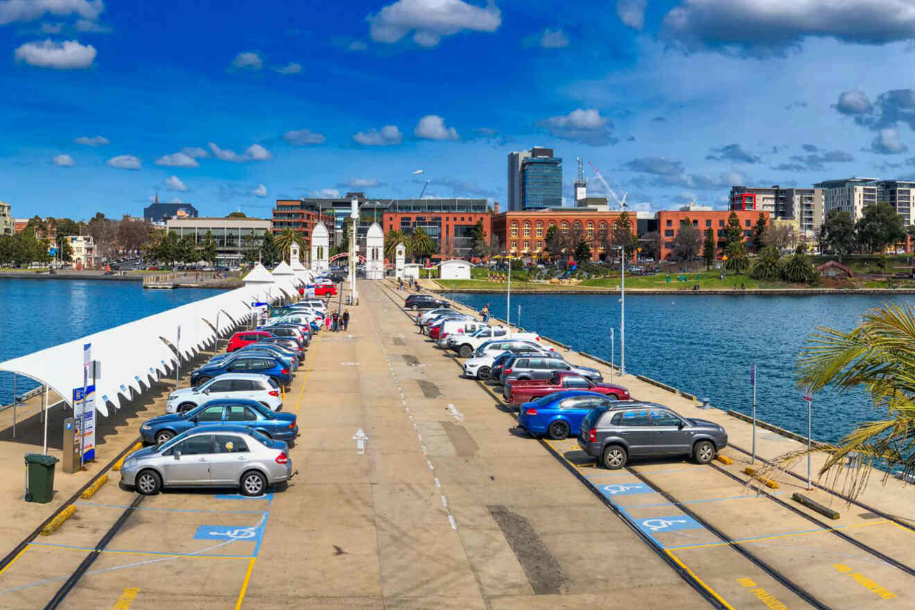 Cars parked on a pier near a body of water.