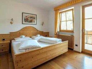 A bedroom with wooden floors and a wooden bed.