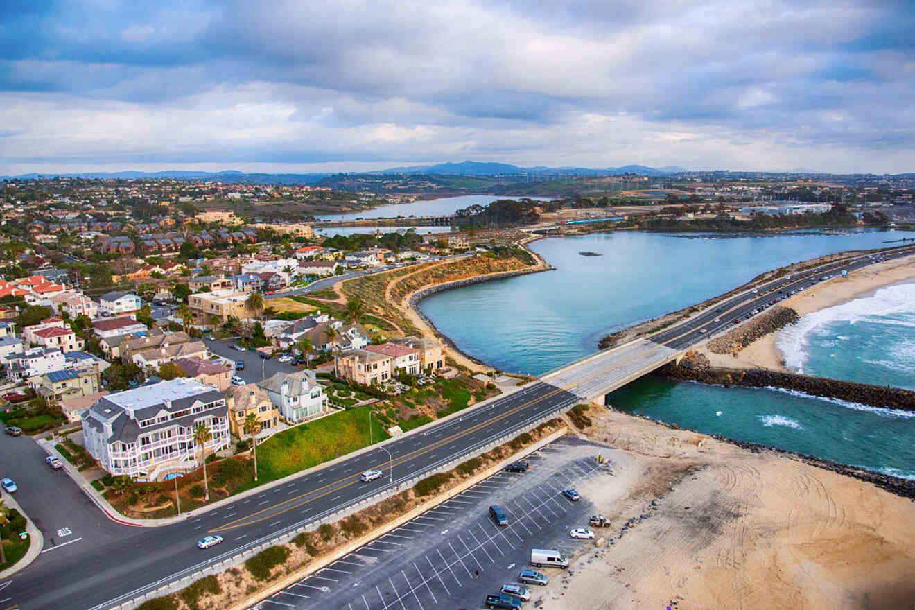 An aerial view of a beach with houses and a bridge.