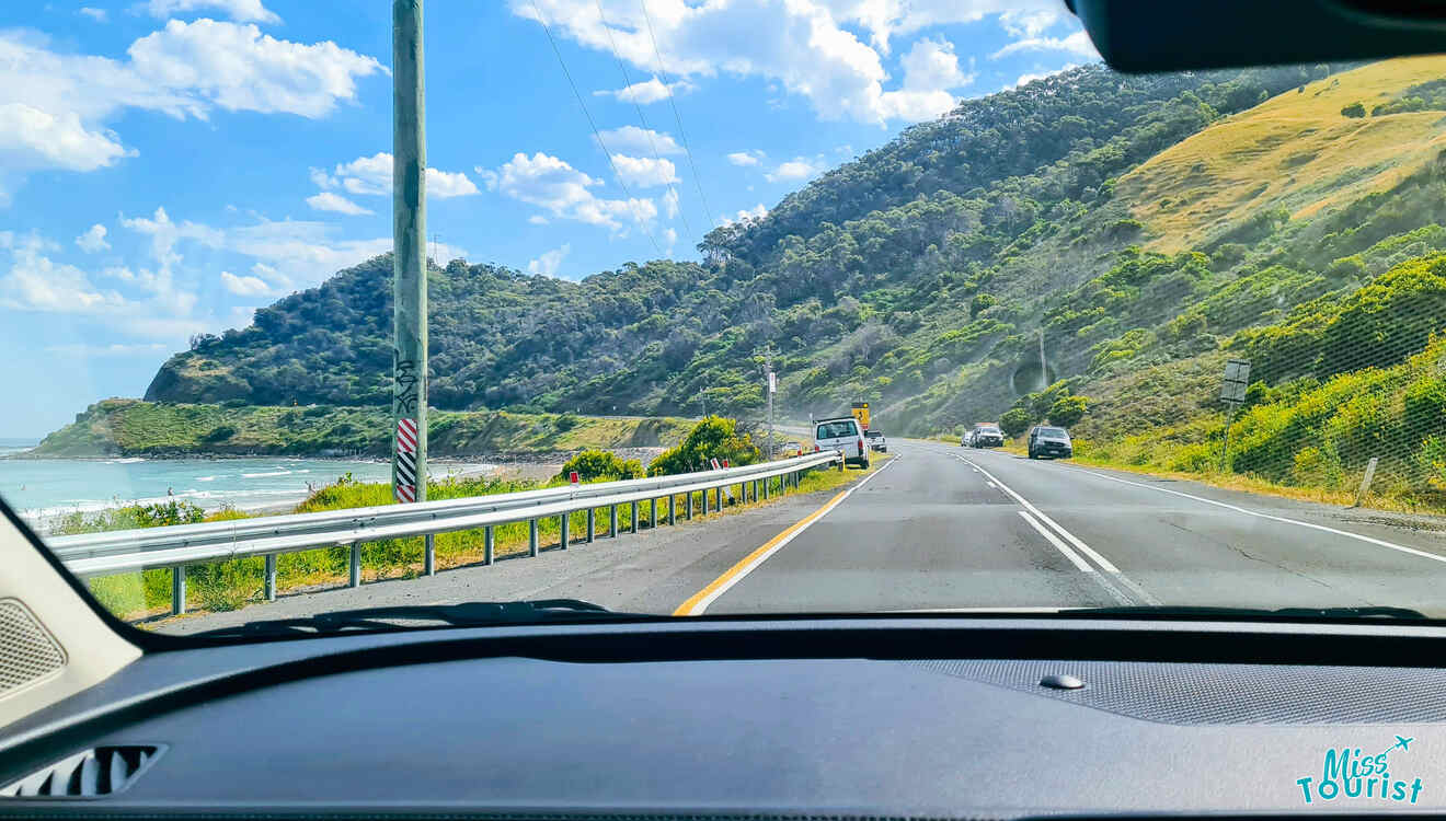 A car driving down a road with a view of the ocean.