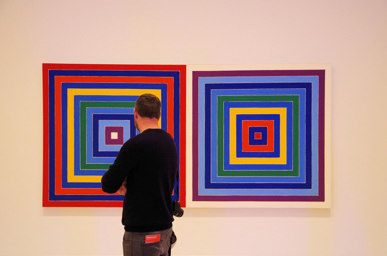 a person looking at abstract paintings