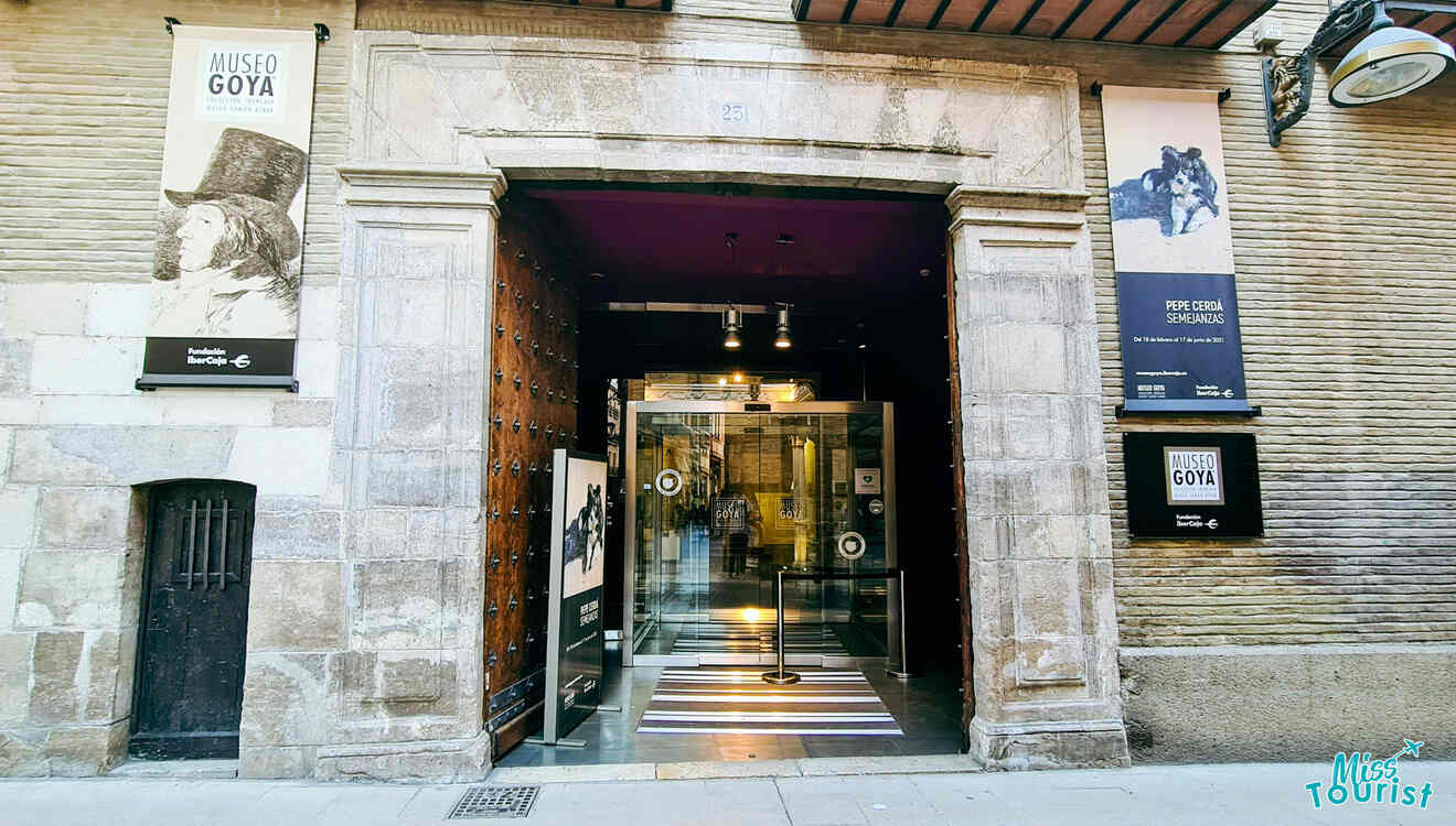 The entrance to a building with a sign on it Mueo Goya