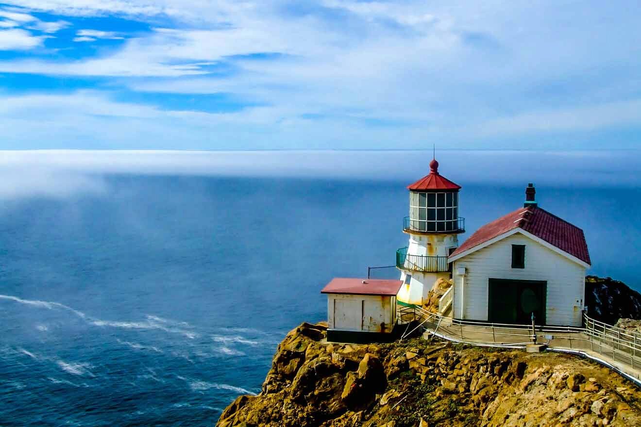 A lighthouse sits on top of a cliff overlooking the ocean.