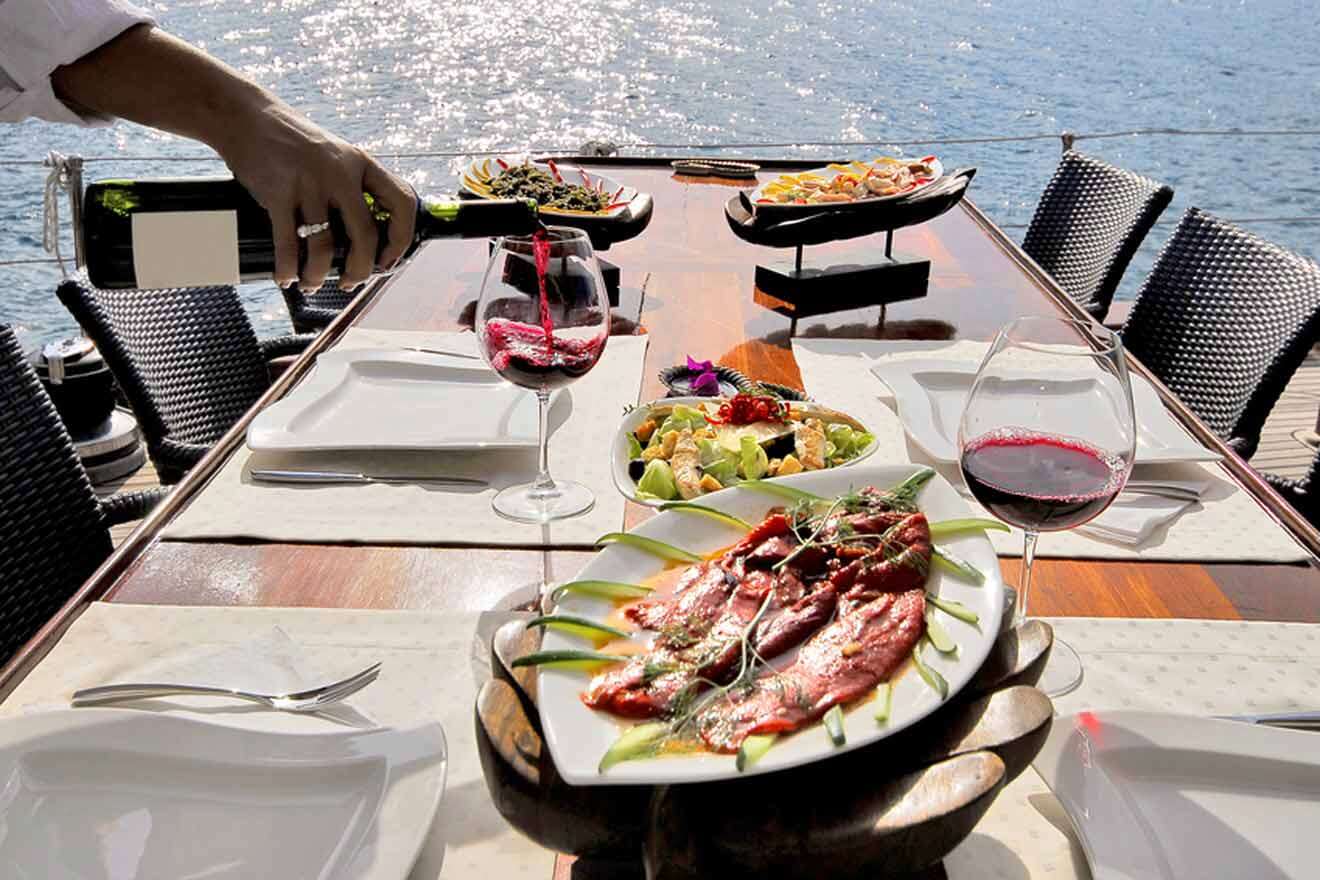 a table with plates of food and glasses of wine on a cruise