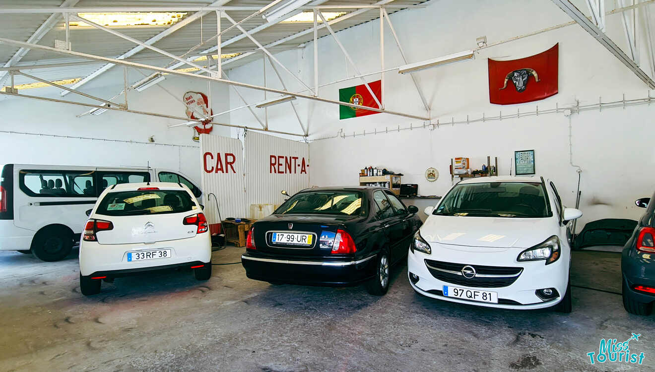 A garage with several cars parked in it.