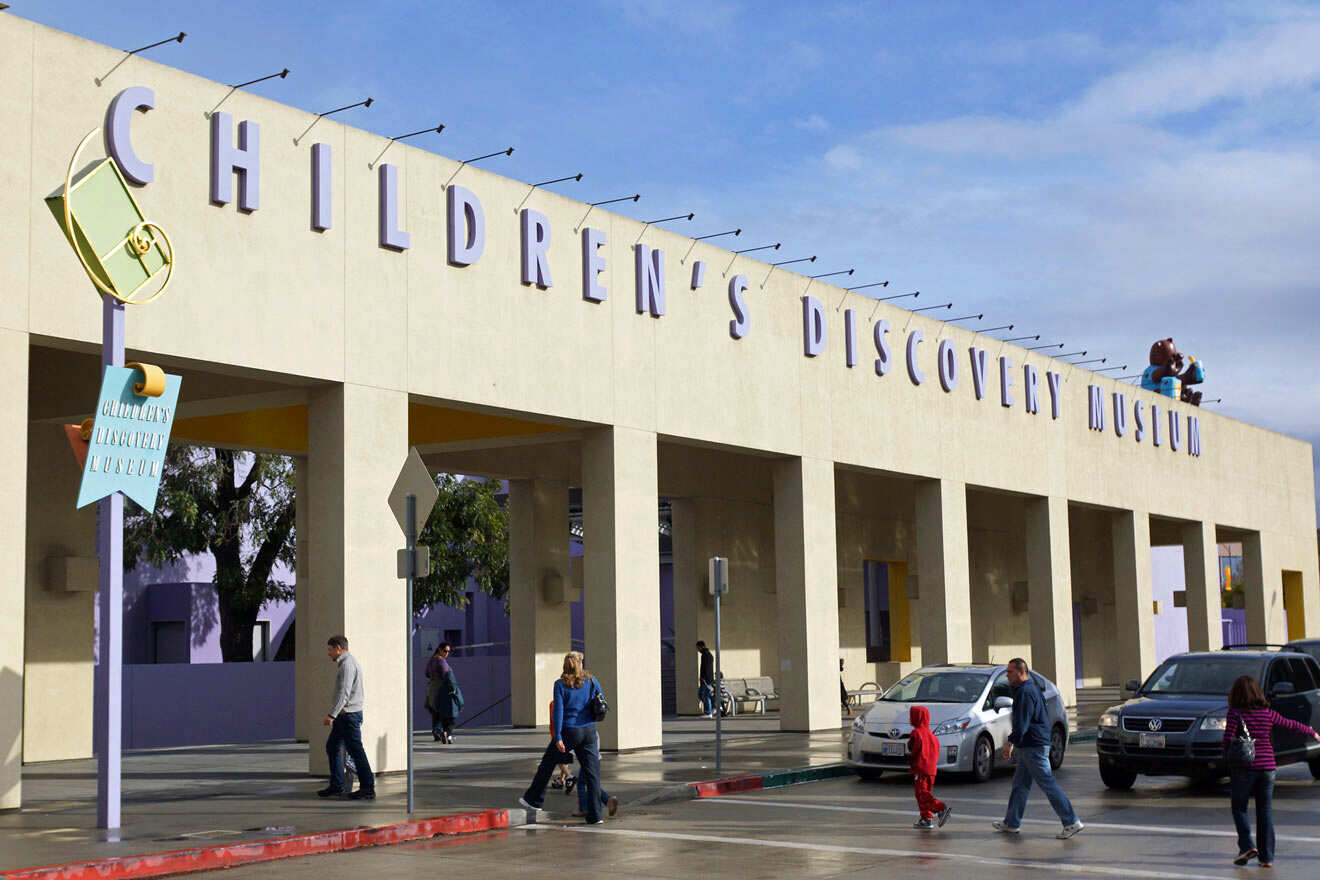 large building with people walking around and parked cars