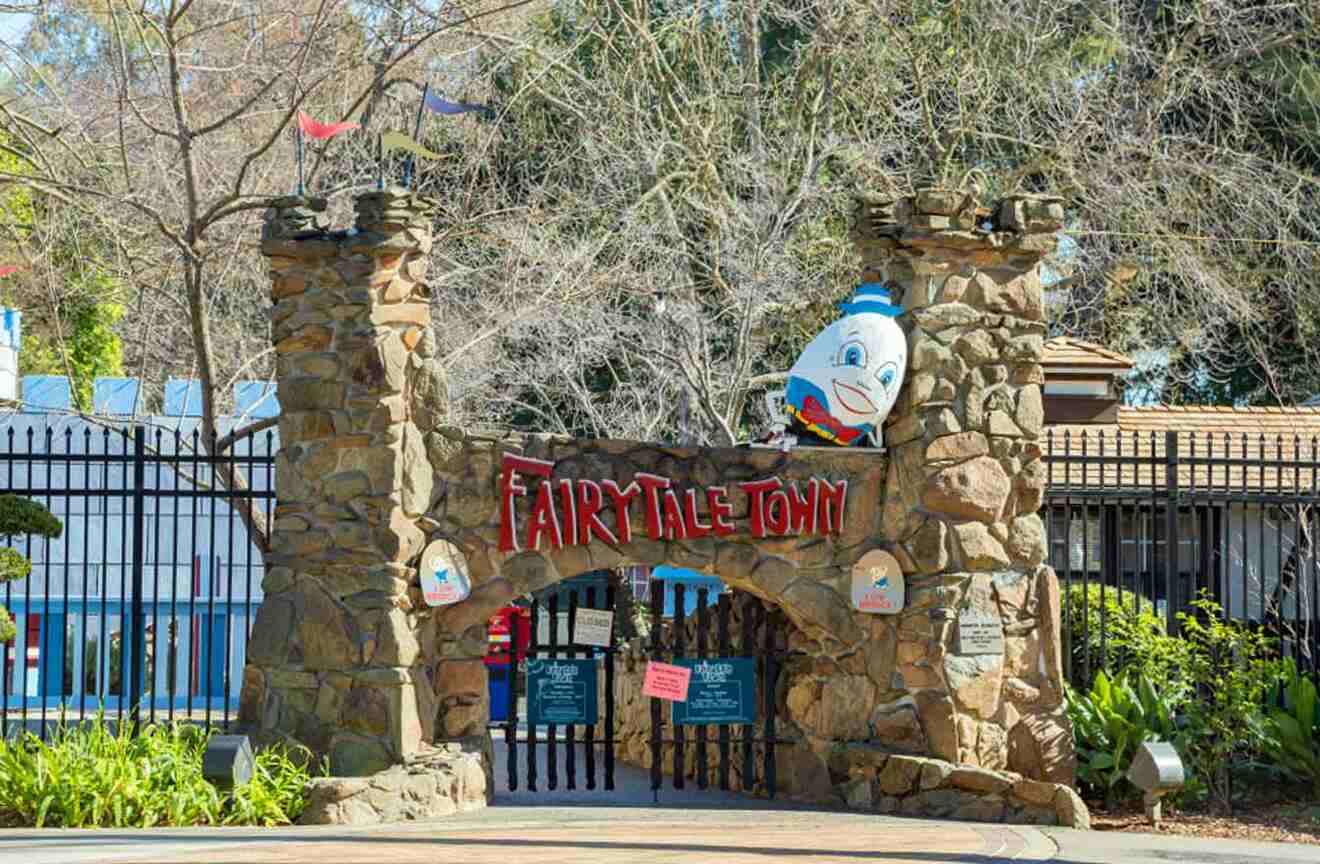 The entrance to a theme park with a statue of a cartoon character.