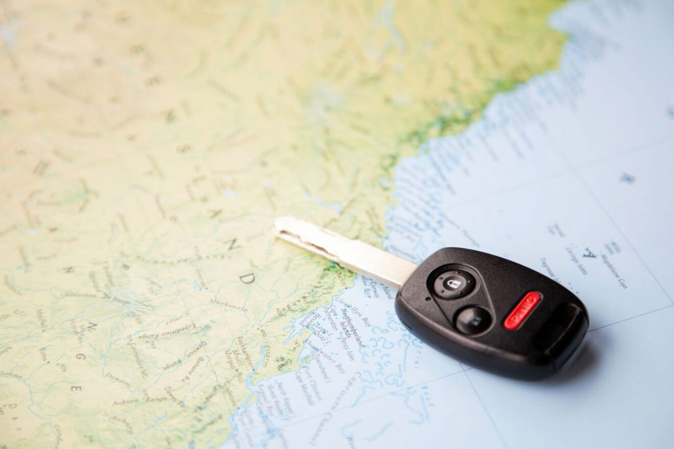 A car key is sitting on top of a map